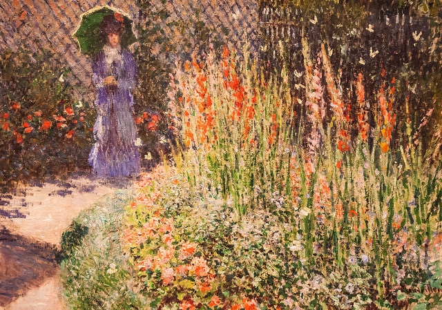 Woman in garden of Gladioli. Gladioli symbolize strength.
